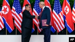 美国总统川普和朝鲜领导人金正恩在新加坡会晤协议后握手。(2018年6月12日)