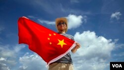 一位中国人在西沙群岛上展示国旗(2014年9月14日)