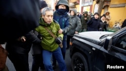 中国警察把一名正在天津法庭外支持维权律师王全璋的支持者抓走塞入警车。(2018年12月26日)