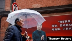 "两会“召开前夕,一名男子在上海街头一幅有习近平像的宣传板前走过。