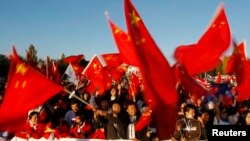 资料照:中国在新西兰的支持者在澳大利亚堪培拉迎接奥运火炬的仪式上挥舞中国国旗。(2008年4月24日)