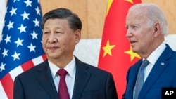 资料照片: 2022年11月14日印度尼西亚巴厘岛G20峰会期间美国总统拜登(右)与中国国家主席习近平站在一起