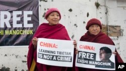 两名藏人尼姑在印度达兰萨拉展示要求中国释放扎西文色的标语牌。(2017年1月27日)