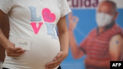 2021年7月23日,一怀孕女子在哥伦比亚波哥大一疫苗接种中心接受了辉瑞疫苗接种之后拿到了接种卡。