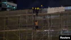 一名抗议者从太古广场大楼周围的施工脚手架上掉下来,当时消防队员正试图营救他。(2019年6月15日)。