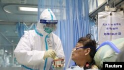 武汉大学中南医院隔离病房中的一名护士星期六(2月8日)正在照顾一名病毒感染者。