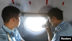 在越南土珠岛附近参加搜救的越南空军人员在飞机上对海面进行拍照。(2014年3月10日)