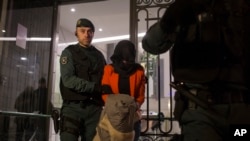 西班牙国民警卫队的一名警察将一名被拘押的女子带离中国工商银行在马德里的办事处。(2016年2月17日)