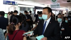 泰国公共卫生部长阿努丁在曼谷的一个高架轻轨车站发放疫情防护口罩。(2020年2月7日)