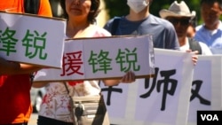 一些华人举牌支持遭到中国维稳当局打压的锋锐律师事务所(美国之音国符拍摄)