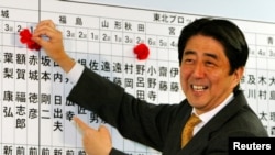 资料照- 本照片摄于2003年11月9日。当时作为执政的日本自民党总干事的安培晋三正帮着记录本党参选人的进展情况,每当本党参选人获胜,安倍就在他们的名字上面插一朵小花。67岁的日本前首相安倍晋三星期五(7月8日)在奈良遭枪击,因伤势过重,不治身亡。(路透社)