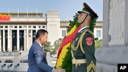 在这张新华社发布的照片中,2023年9月14日星期四,柬埔寨首相洪马内在北京天安门广场向人民英雄纪念碑敬献花圈。(Yue Yuewei/Xinhua via AP)