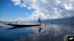 An ethnic Inntha fishermen on boats use their fishing net in Inlay lake, Nyaung Shwe township, southern Shan State, Myanmar, Wednesday, Oct. 1, 2014.