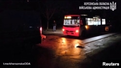 A person stands near a civilian passenger bus after a Russian drone attack at a location given as Kherson, Kherson Region, Ukraine, in this screen grab obtained from a handout video released on Jan. 6, 2025. (Kherson Regional State Administration/Handout via REUTERS)