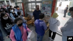 资料照片:2022年11月26日,台湾举行“九合一”选举。选民正在一个投票站等候投票。