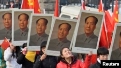 中国山西省太原一所大学的学生手举中共前领导人毛泽东的画像庆祝毛泽东诞辰120周年。(2013年12月21日)
