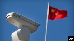 北京的一处海康威视监视摄像头旁飘扬的中国国旗。(2019年10月8日)