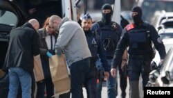 比利时警察对布鲁塞尔斯哈尔贝克区展开搜查后检查收集在口袋里的物证。(2016年3月25日)