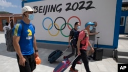 到河北省张家口崇礼的游客走过北京2022冬季奥运会的广告牌。(2020年8月13日)