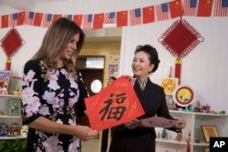 美国第一夫人梅拉尼娅·特朗普和中国国家主席习近平夫人彭丽媛访问北京板厂小学,两人手持学生写的福字(2017年11月9日)。