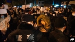 2022年11月27日,北京一些抗议人士手举表达不满的白纸与警察对峙。周末中国好几个地方发生了街头抗议。这些抗议的爆发随然令人意外,但作为统治者的中共甚至早在1989年“六四”血腥镇压学生抗议示威之后就一直在防备类似事件再次出现。