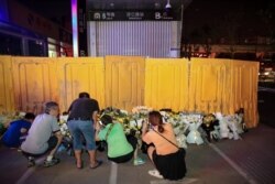 河南郑州市民在被黄色围栏围起来的地铁5号线车站前献花悼念水灾死难者。(2021年7月26日)