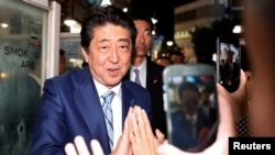 2017年10月20日,日本首相自民党领袖安倍晋三在一场选举造势活动后,向选民们问好。