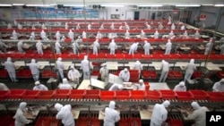 双汇集团在中国河南省漯河的一家猪肉加工厂生产线上的员工。(资料照)