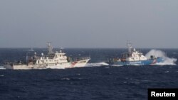 资料照:在距离越南海岸约210公里(130英里)的南中国海,越南海上警卫队的一艘船(右)靠近一艘中国海警船。 (2014年5月14日)