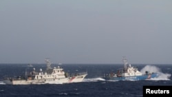 资料照:在距离越南海岸约210公里(130英里)的南中国海,越南海上警卫队的一艘船(右)靠近一艘中国海警船。 (2014年5月14日)