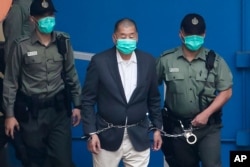 资料照:香港警察押着壹传媒创始人黎智英走向警车前去出庭。(2020年12月12日)