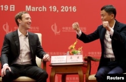 在北京的中国发展论坛会议上,脸书公司创办人和CEO扎克伯格看着马云讲话(2016年3月19日)
