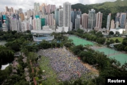 2019年6月9日在香港维多利亚公园,示威群众要求当局废除拟议中的把犯人引渡到中国的法案。他们手持黄色遮阳伞,这是过去的占领中环运动的象征。
