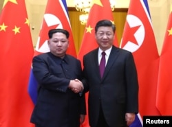中共中央总书记、国家主席习近平和鲜劳动党委员长、国务委员会委员长金正恩在北京人民大会堂握手(2018年3月28日发布的照片)