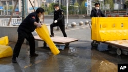 日前湖北省武汉市解除封锁,工作人员在移除道路上的障碍物。(2020年4月7日)