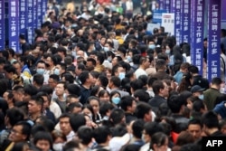 大批青年在重庆举办的一个招聘会上寻找工作。(2023年4月11日)