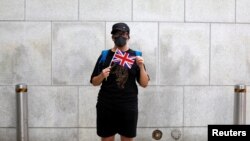 一名香港抗议者在英国驻港总领事馆外手举英国国旗。(2019年8月21日)