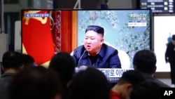 2021年3月25日,在首尔的一个火车站,乘客观看新闻节目时出现的金正恩画面。