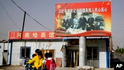 资料照:新疆和田一家面馆上树立的中国领导人习近平与维吾尔族老人在一起的照片。(2018年9月20日)