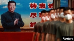 资料照片:武警在北京紫禁城门的习近平画像前排队集合。(2020年5月22日)