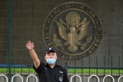美国驻北京大使馆外的一名中国保安在做手势。(2020年9月12日)