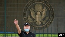 资料照片:美国驻北京大使馆外的一名中国保安在做手势。(2020年9月12日)