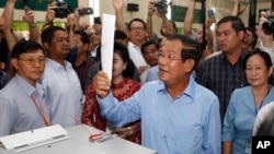 已经统治了33年的柬埔寨首相洪森带着他的妻子到达金边郊区的电视台投票(2018年7月30日)