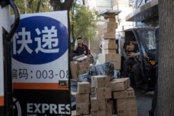 资料照:北京街头快递小哥在分发运送包裹(2019年11月11日)