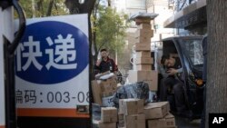 中国“光棍节”当天,北京街头快递小哥在分发运送包裹(2019年11月11日)
