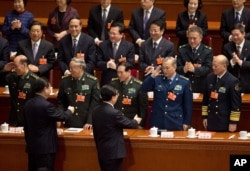 2013年3月14日,卸任的中国党政军领导人胡锦涛和接任的习近平进入北京人民大会堂参加人大会议时一道接受军队代表团的致意