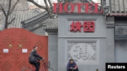 一名佩戴红袖章的北京居民自称自己是自愿保安员,在北京市中心一个胡同口执勤。(2019年2月28日)