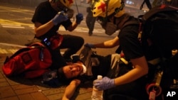 在香港警察动用催泪瓦斯后,救护人员帮助一名抗议者。(2019年7月21日)
