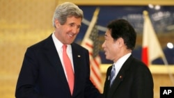 日本外务相岸田文雄(右)2013年4月14日在东京外务省宾馆迎接美国国务卿克里(左)