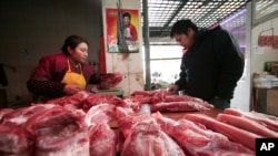 在上海,一位顾客在肉铺挑肉(资料照片)